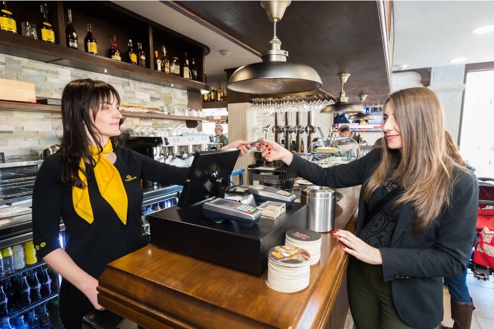 Mujer pagando en una cafetería
